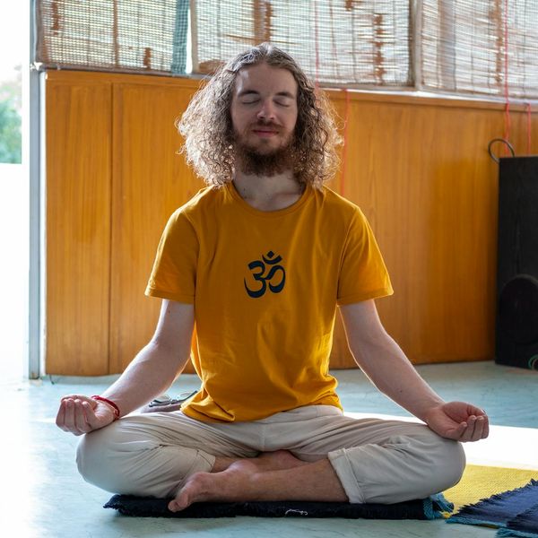 Person meditating in a peaceful setting, symbolizing well-being.